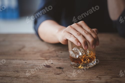 Preview: Man holding a glass of brandy, he is drinking brandy in a bar.