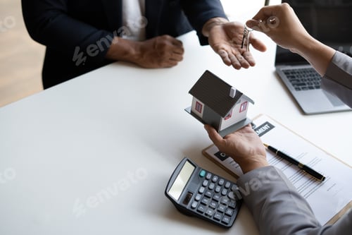 Preview: Close up view of real estate agent giving key from house to costumer.