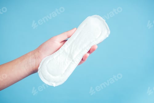 Preview: white sanitary napkin iin the girl's hand on a blue background