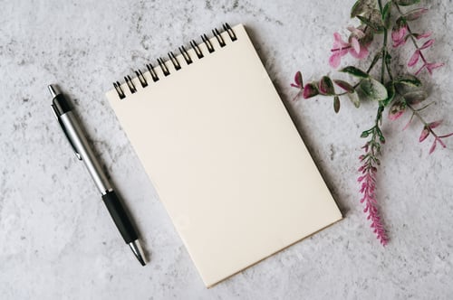 Preview: notebook, pen and flower is placed on white background
