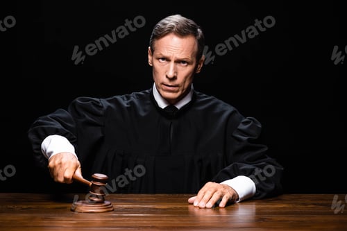 Preview: judge in judicial robe sitting at table and hitting with gavel isolated on black