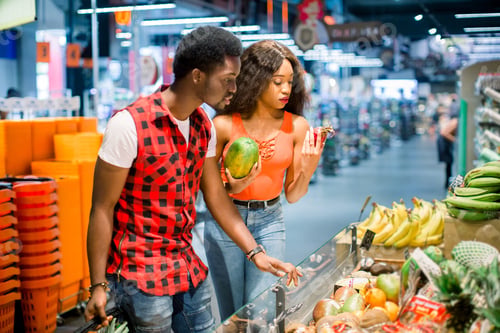 Preview: Young african couple in casual clothes choosing vegetables and fruits