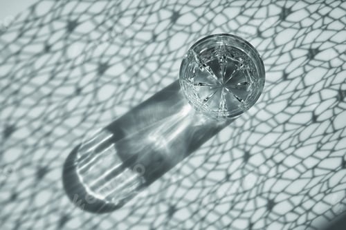 Preview: a glass of water and shade from the sun from the curtains and glass