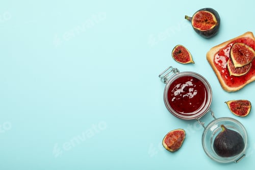 Preview: Figs, jars of jam and bread with jam on blue background, space for text