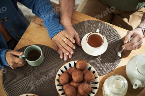 Preview: Elderly Couple Drinking Tea Around Wooden Table