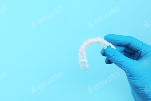 Preview: Dentist holding teeth cover on color background. Space for text