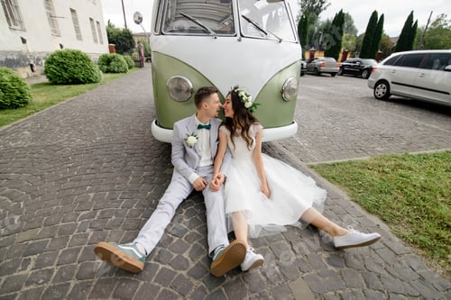 Preview: Hipster bride and groom are sitting near their retro bus.