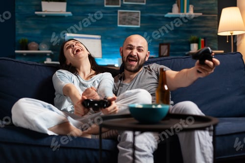 Preview: Focused determined couple playing soccer video game late night