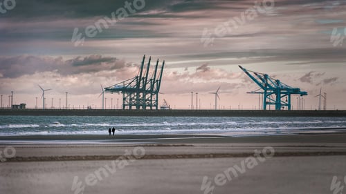 Preview: Couple walking on a beach with port crane in the background