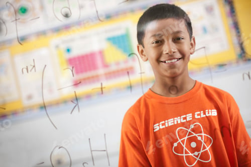 Preview: A boy looking at a board with written scientific equations and calculations.