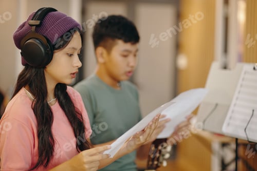 Preview: Practicing Singing in Studio with Headphones and Music Sheets