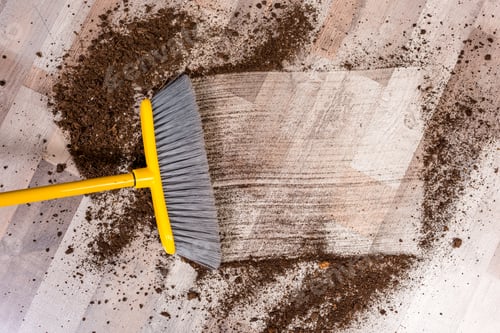 Preview: Close-up top view of broom sweeping floor with soil