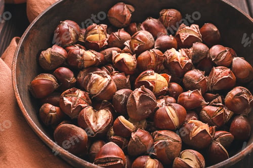 Preview: Roasted chestnuts, in an iron pan, wooden table, top view, no people, rustic style,