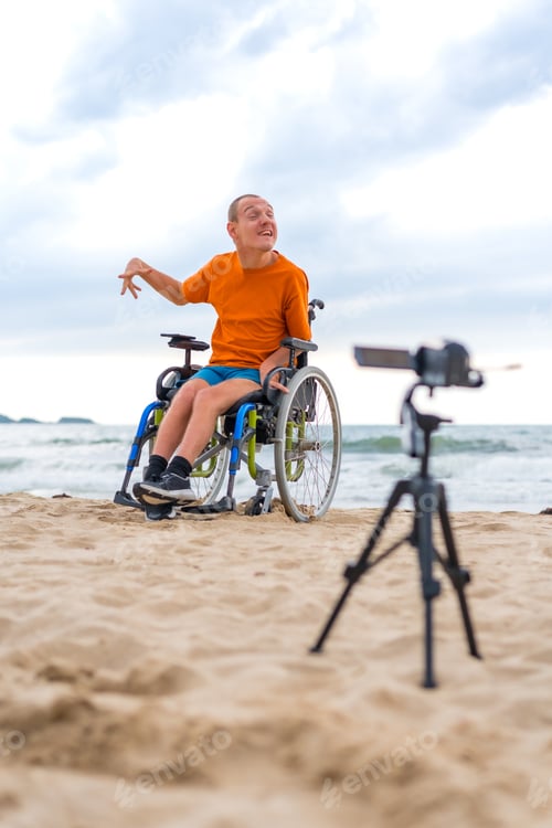 Preview: A disabled person in a wheelchair recording a video next to the beach