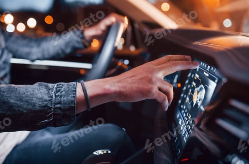 Preview: Using navigation display. Handsome unshaved man in fashionable clothes riding his automobile
