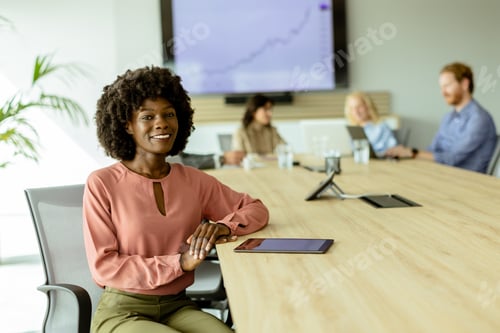 Preview: Confident young African American businesswoman smiling during a creative brainstorming session