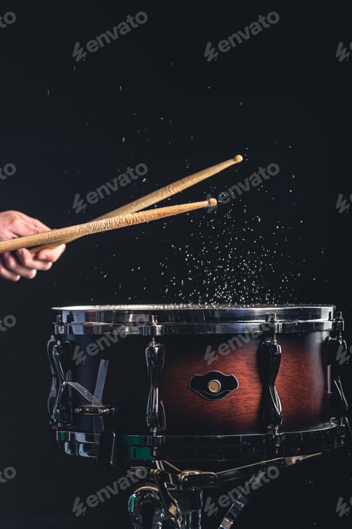Preview: A man plays the snare drum against a dark background.