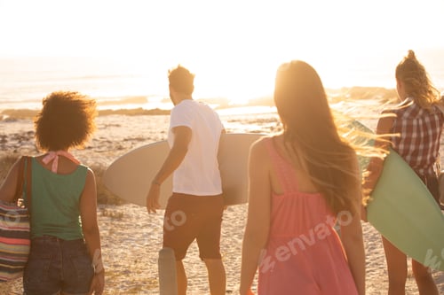Preview: Rear view of diverse friends walking towards the beach