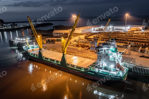 Preview: Cargo Ship Docked at a Port at Night Offloading Cargo