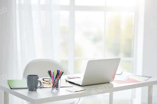 Preview: Home office. Workplace with white laptop, notes and cup of tea on the table at home. Bright light