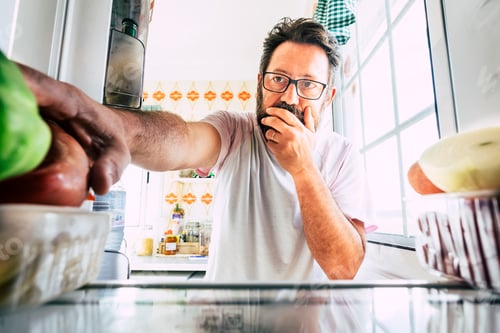 Preview: Adult caucasian man looking inside the fridge
