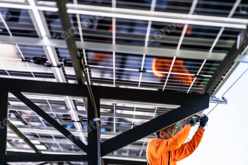 Preview: Engineer in safety vest and helmet pointing towards a solar powered carport