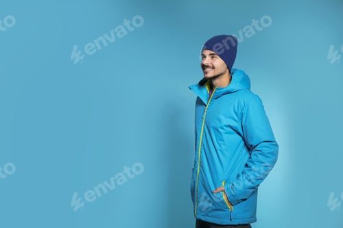 Preview: Young man wearing warm clothes on color background, space for text. Ready for winter vacation