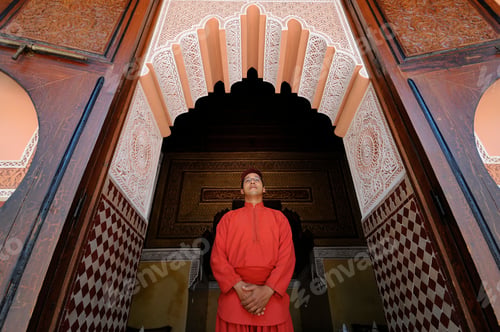 Preview: A person in traditional attire admiring the intricate architecture of an ornate doorway