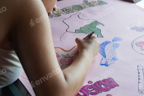 Preview: young latin woman making a poster about the colombian amazon region. studying about the culture