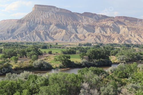 Preview: Grand Mesa with the Colorado River running through a lush valley in Grand Junction, Colorado