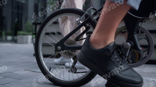 Preview: Closeup male legs pedaling riding shared bicycle. Modern city transportation.
