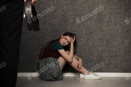 Preview: Man with belt standing in front of crying woman indoors, space for text. Stop sexual assault