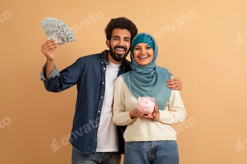 Preview: Portrait Of Happy Muslim Couple With Piggybank And Dollar Cash In Hands