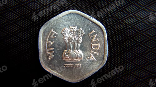 Preview: Closeup overhead shot of a coin displaying Indian currency on a dark background