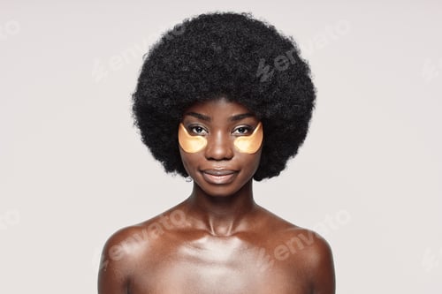 Preview: Portrait of beautiful young African woman with patches near eyes looking at camera