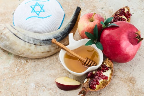 Preview: Rosh Hashanah. Traditional items for Rosh Hashanah shofar, honey, apple, and pomegranate on a rustic