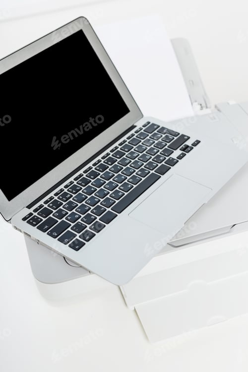 Preview: Laptop on a printer in a modern office setting with minimalistic design during daytime