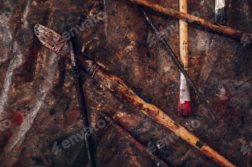 Preview: Dirty paintbrushes laying on the floor of an artist studio