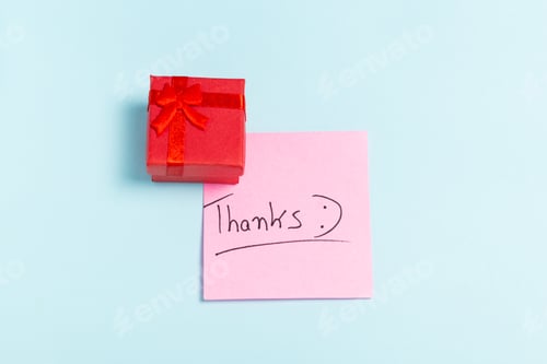 Preview: A red box with a red bow on top of a pink piece of paper that says "THANKS"