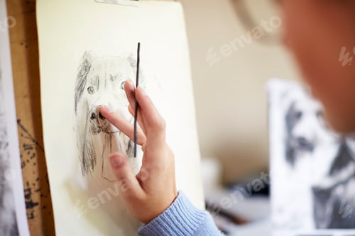 Preview: Close Up Of Female Teenage Artist Sitting At Easel Drawing Picture Of Dog From Photograph