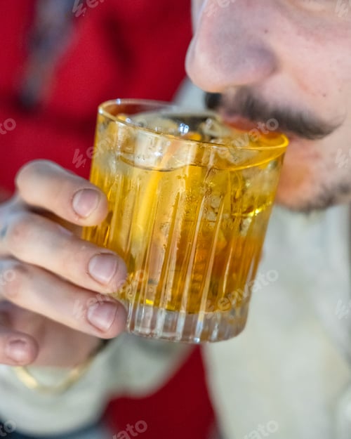 Preview: Unrecognizable young man drinking a cocktail in a bar