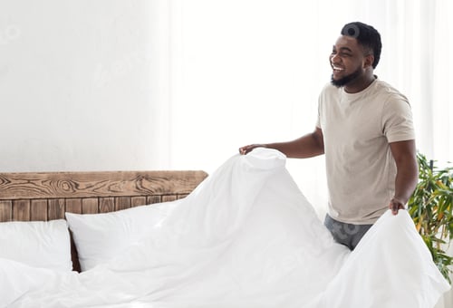 Preview: Happy black guy covering his bed with blanket