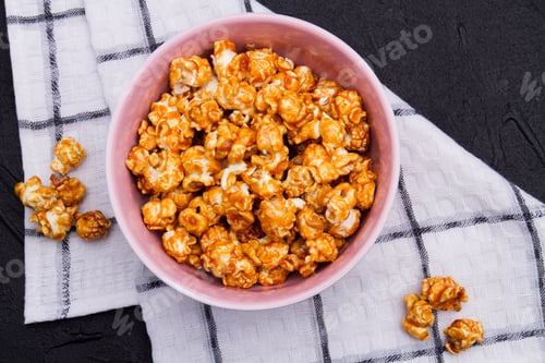 Preview: Close-up golden fried popcorn in ceramic plate on checkered background.