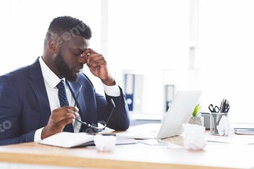 Preview: Tired african american businessman taking his glasses off