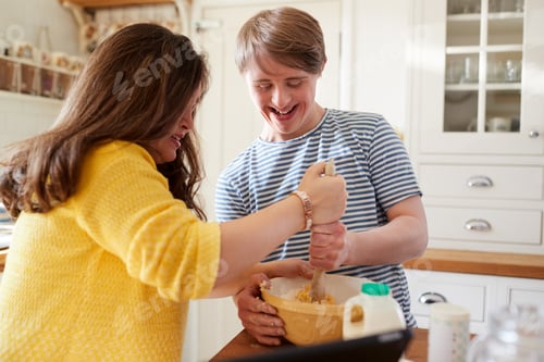 Preview: Young Downs Syndrome Couple Baking In Kitchen At Home