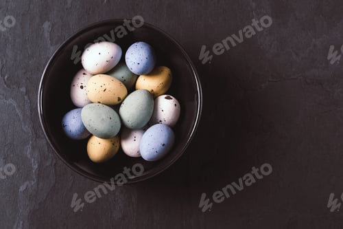 Preview: Candy Easter eggs in a dark bowl on dark background.