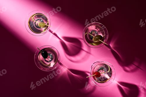 Preview: Top view of cocktails with olives on pink background with shadows