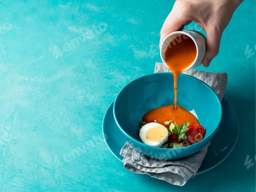 Preview: Hand pouring of Gaspacho soup in bowl