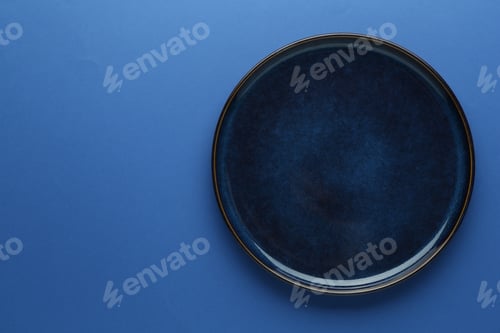 Preview: One stylish plate on blue background, top view. Space for text