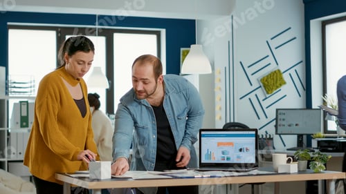 Preview: Startup office worker explaining sales startegy to new employee using laptop with business analytics
